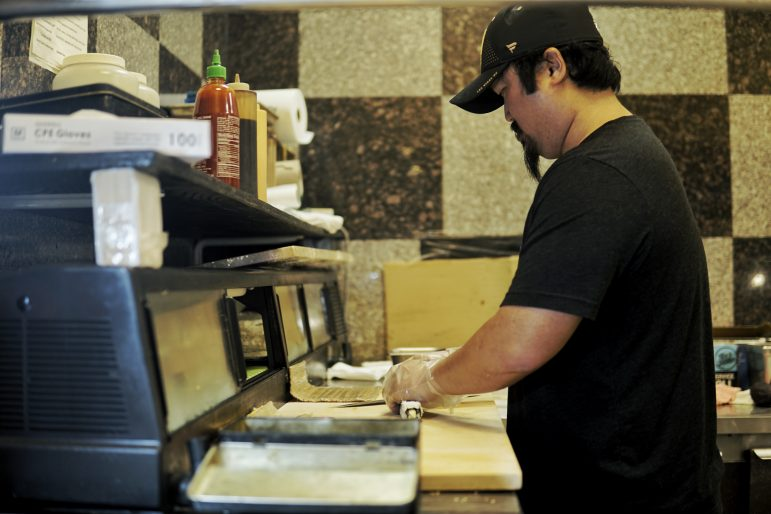 Henry Kwok making a sushi roll in Asian Buffet
